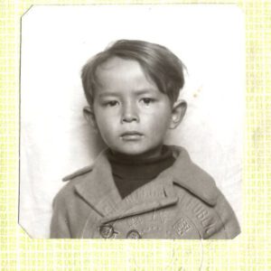 A passport photo of Thomas as a boy just before coming to the United States for his adoption,