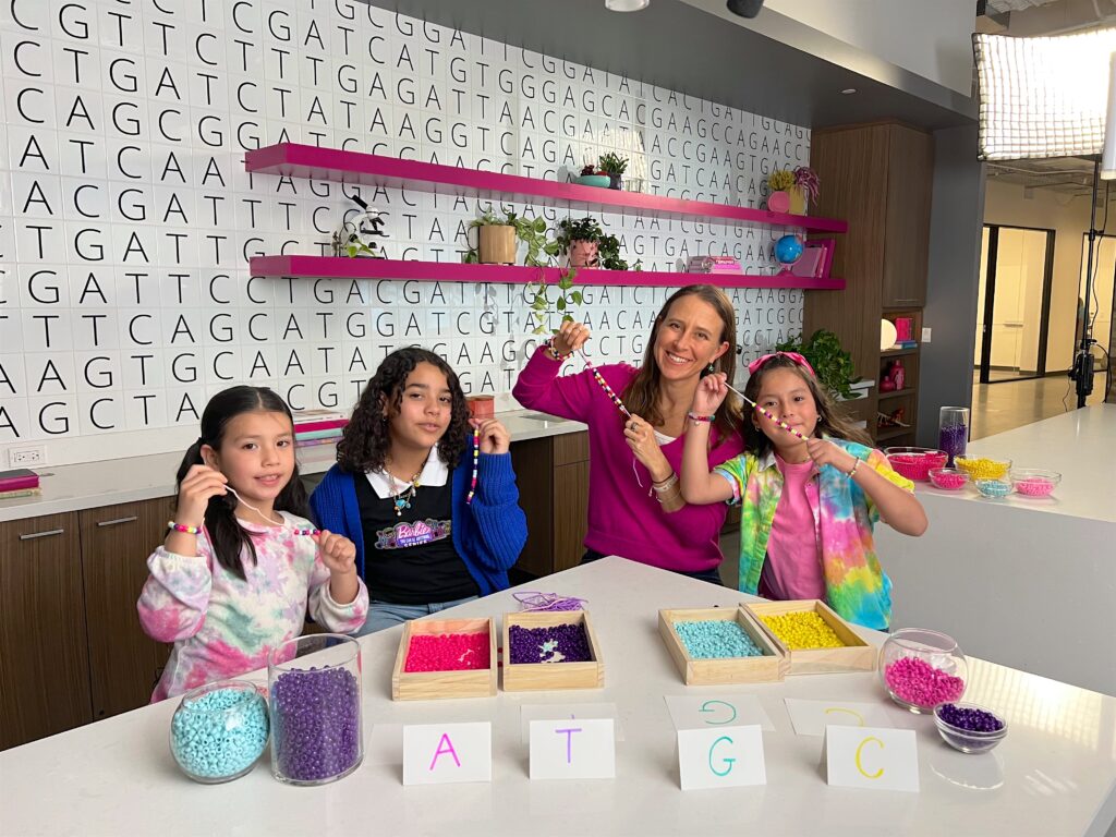 A photo of Anne and three girls holding up their beaded bracelets.